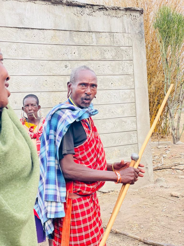 Maasai man bij gebouw bij opgedroogde bron Ilpopong